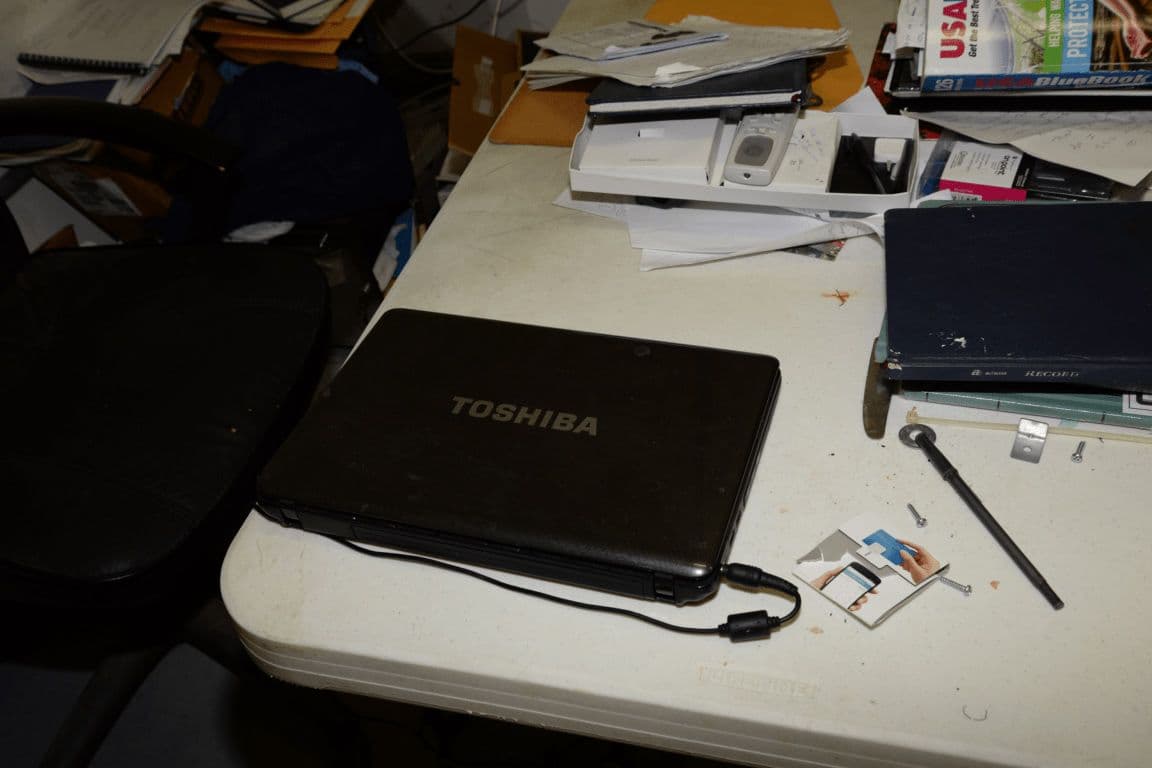 A laptop and papers on a work desk.