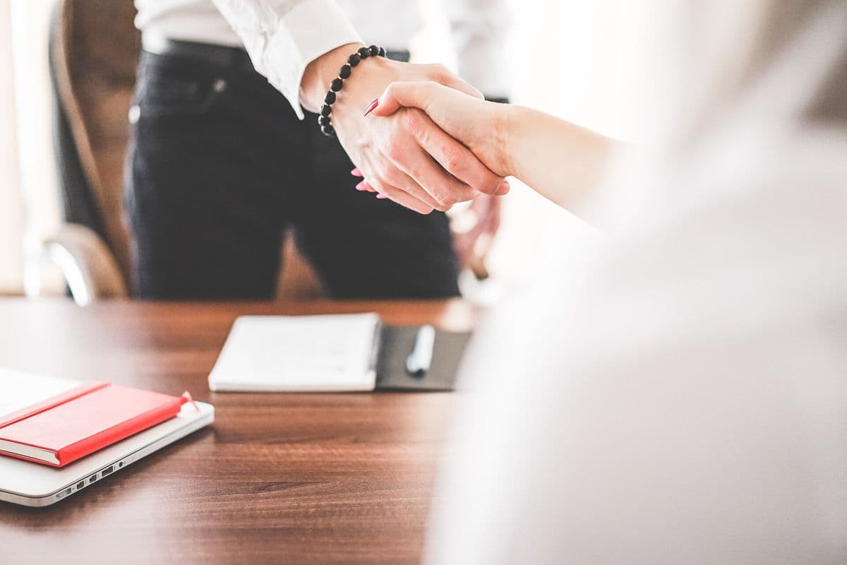Two people shaking hands in an office.
