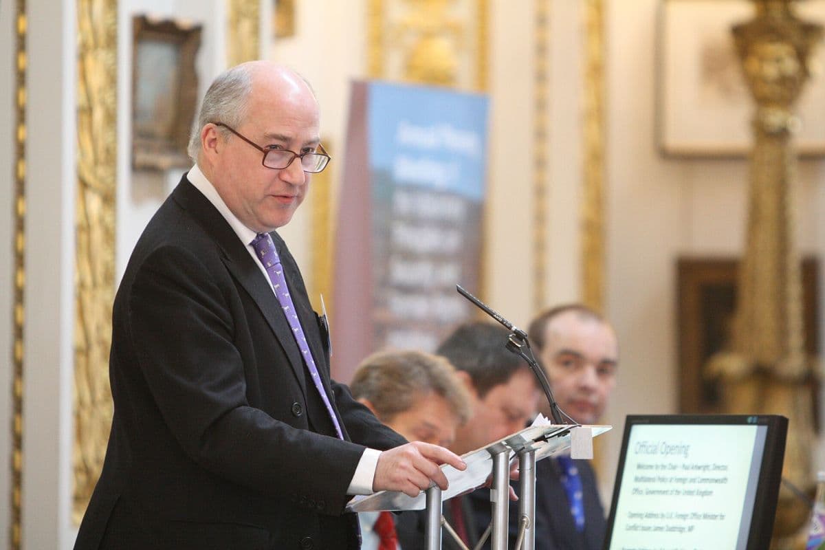A person briefing an audience from a lectern.