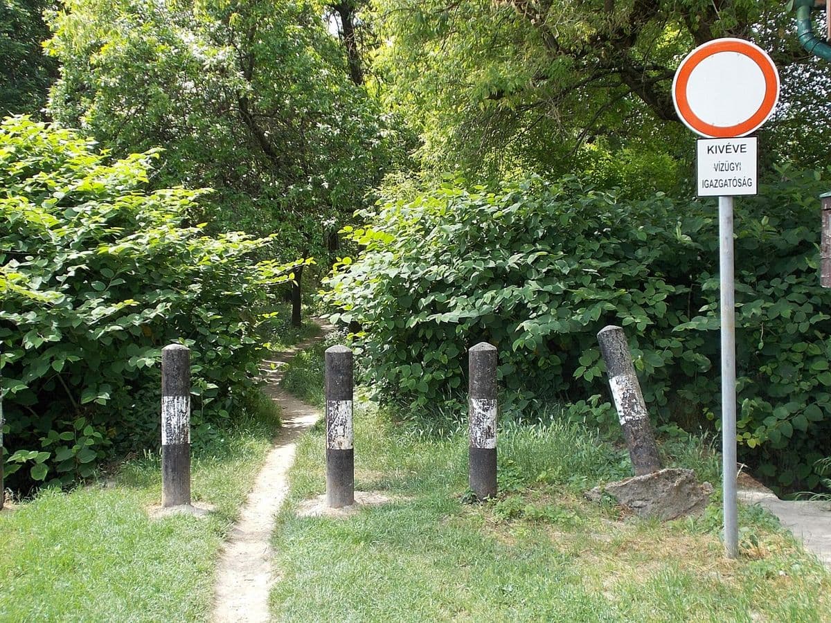 A red-and-white 'no entry' road sign blocking a path, with bollards.