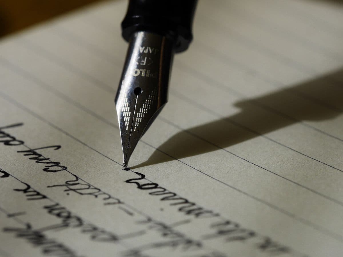 A fountain pen writing in a notebook.