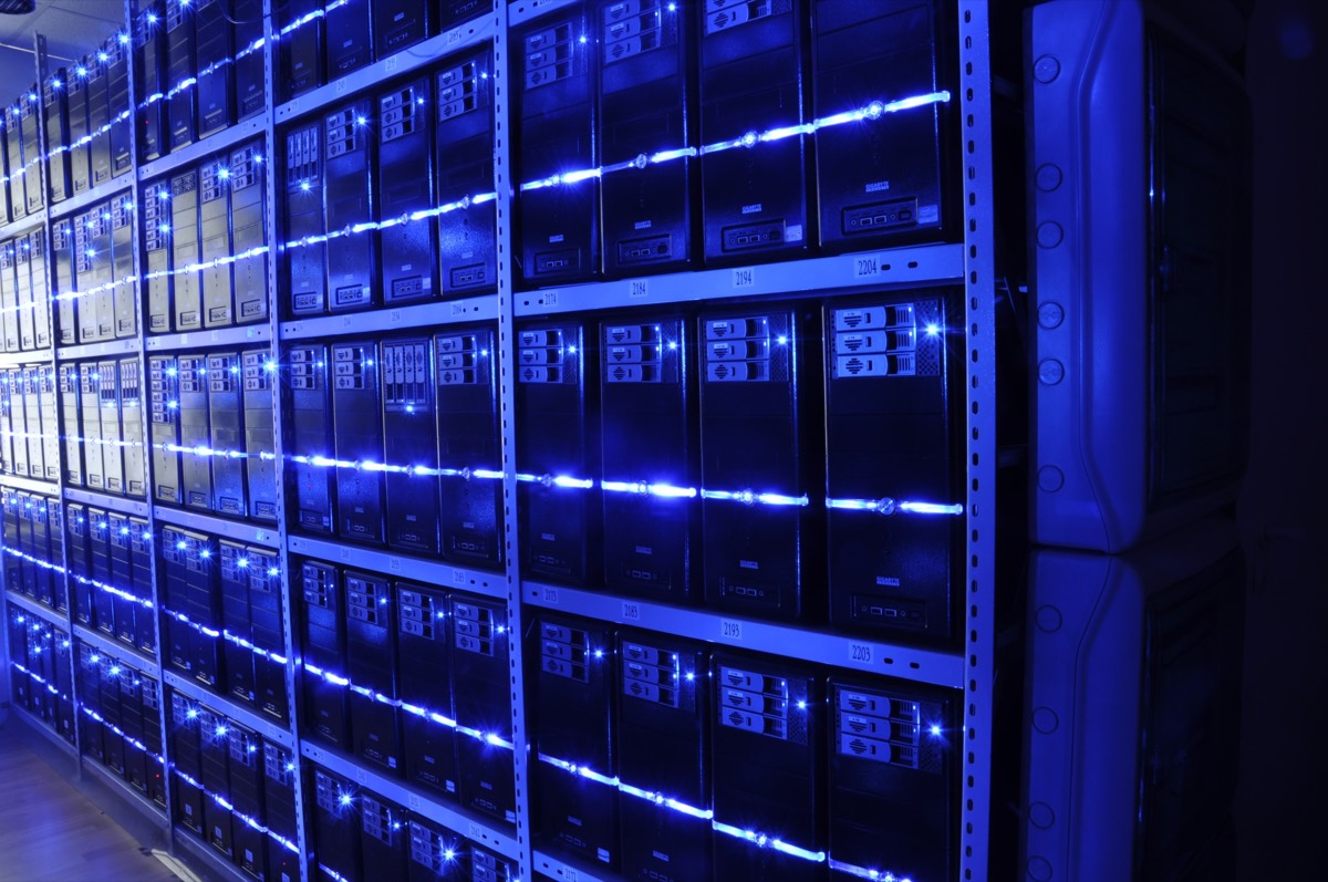 Rows of servers lit blue inside a data centre — the physical machines that 'the cloud' actually runs on.